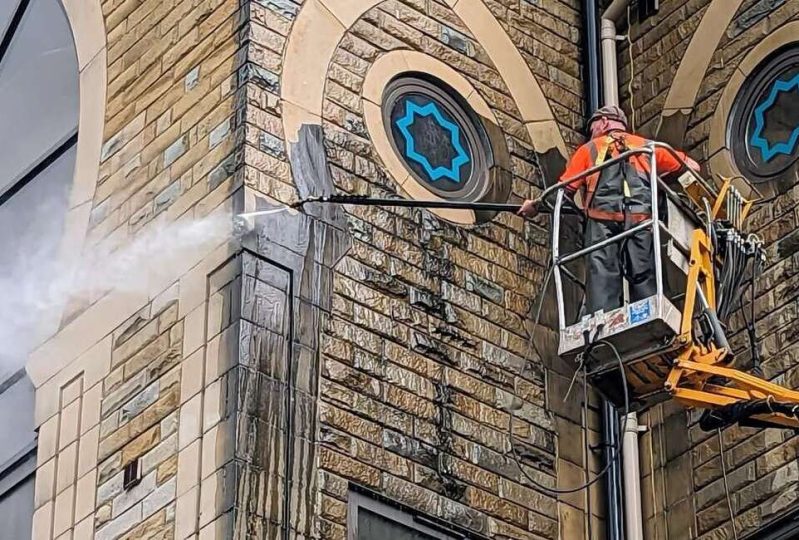 Cleaning an exterior of a building with high pressure jet washing